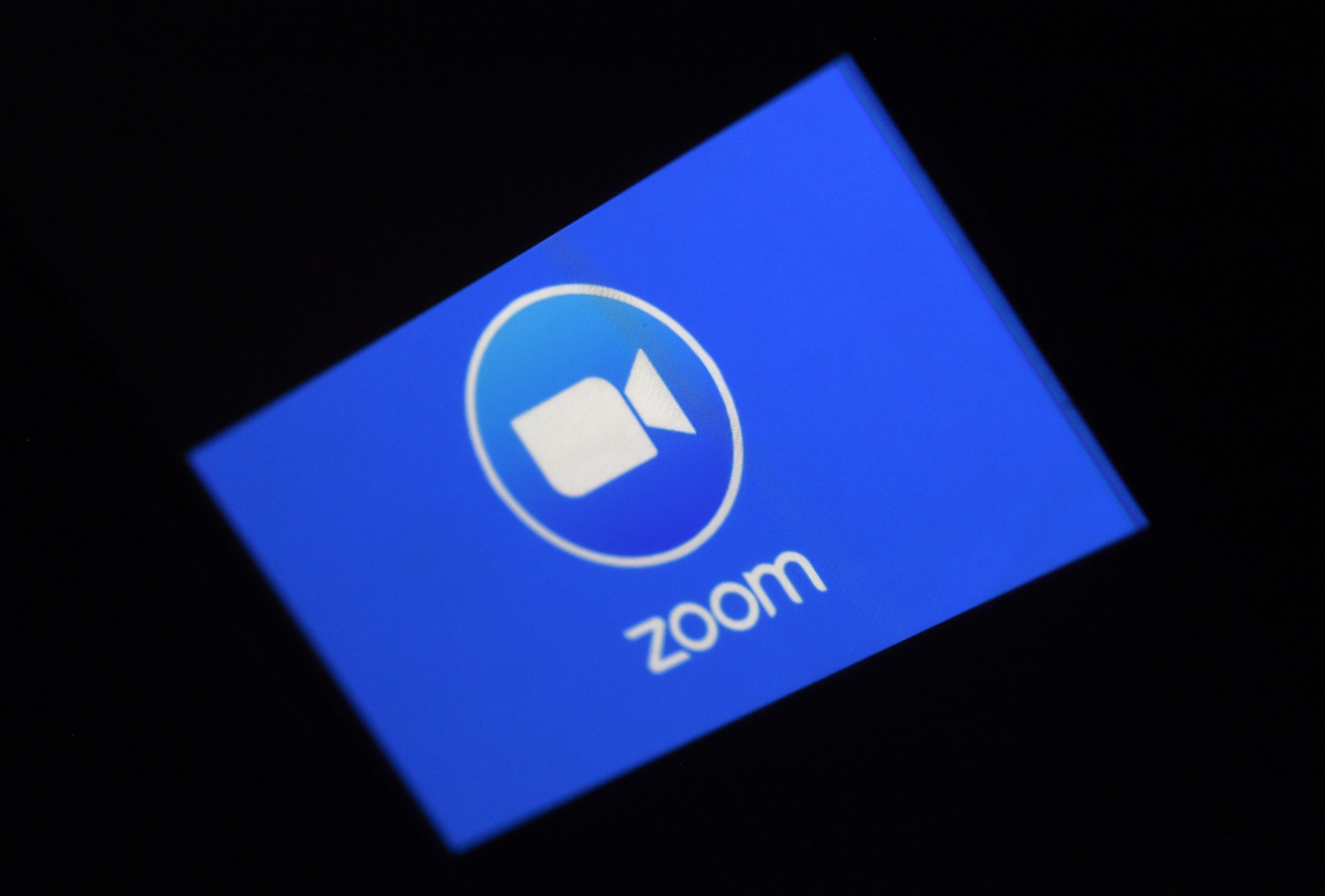 A Zoom App logo is displayed on a smartphone. (AFP Photo)