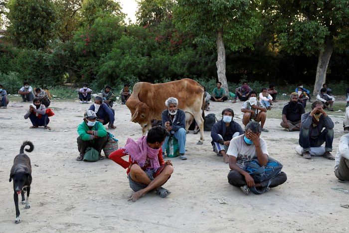 Daily wage workers and homeless people wait on the banks of Yamuna river as police arrange buses to transfer them to a shelter in Delhi, April 15, 2020. Reuters