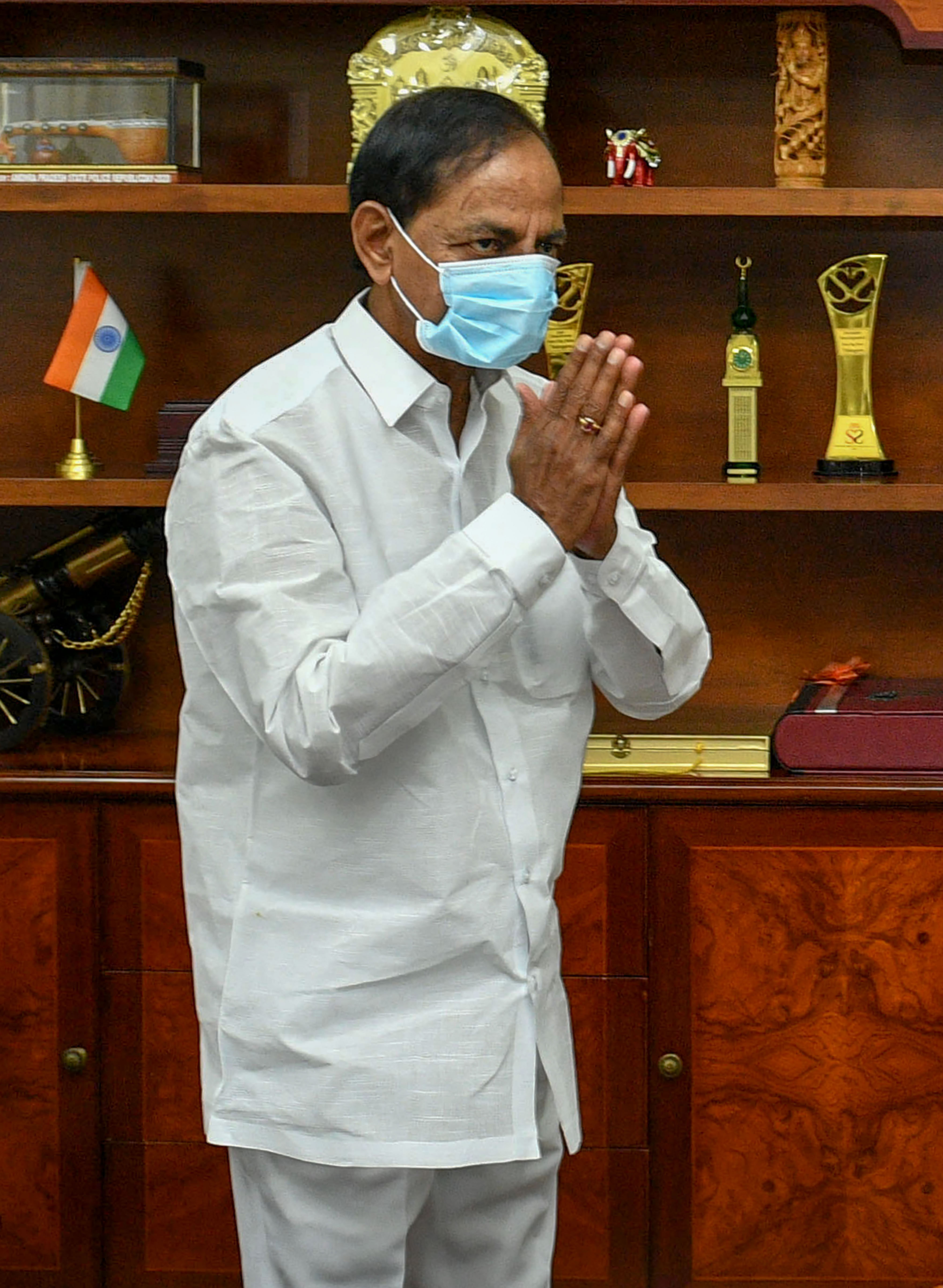 Telangana Chief Minister K Chandrashekar Rao wearing a mask greets as he arrives, in Hyderabad. (Credit: PTI Photo)