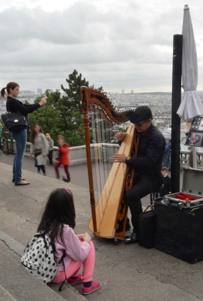 A busker playing the harp in Paris.