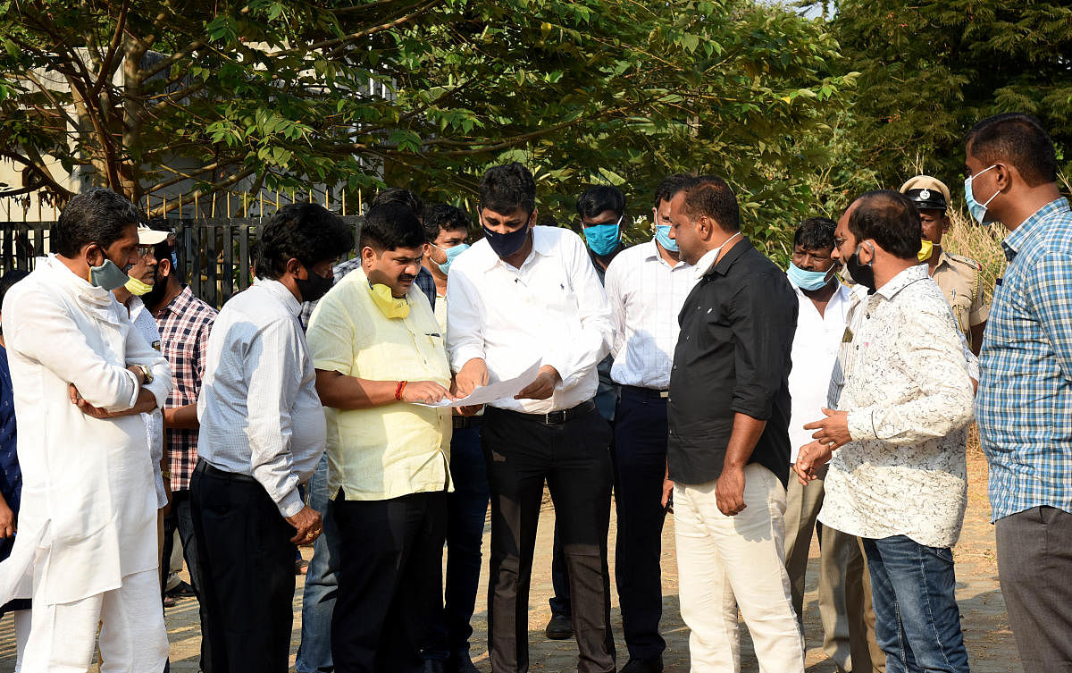 MLAs D Vedavyas Kamath and U T Khader inspect the land identified for construction of temporary sheds for small traders in Mangaluru.
