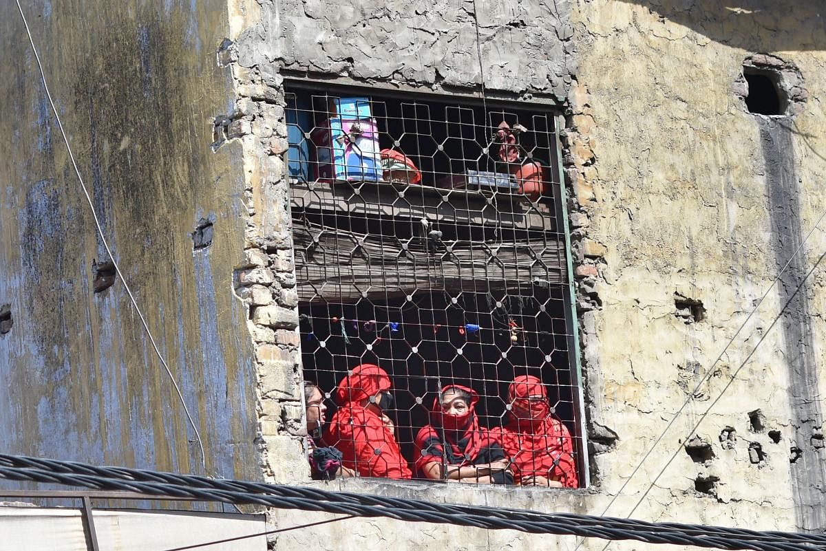 Sex workers look through a window during a nationwide lockdown amid the coronavirus outbreak, at GB Road in New Delhi, Friday, April 3, 2020. Credit: PTI Photo