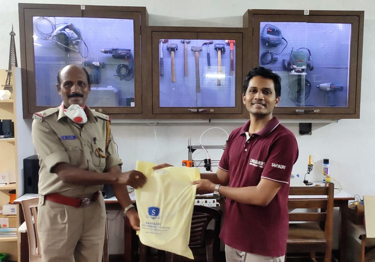 A representative of DreamWorks Makerspace at Sahyadri College of Engineering and Management, hands over face shields to Shivamogga police.ce.
