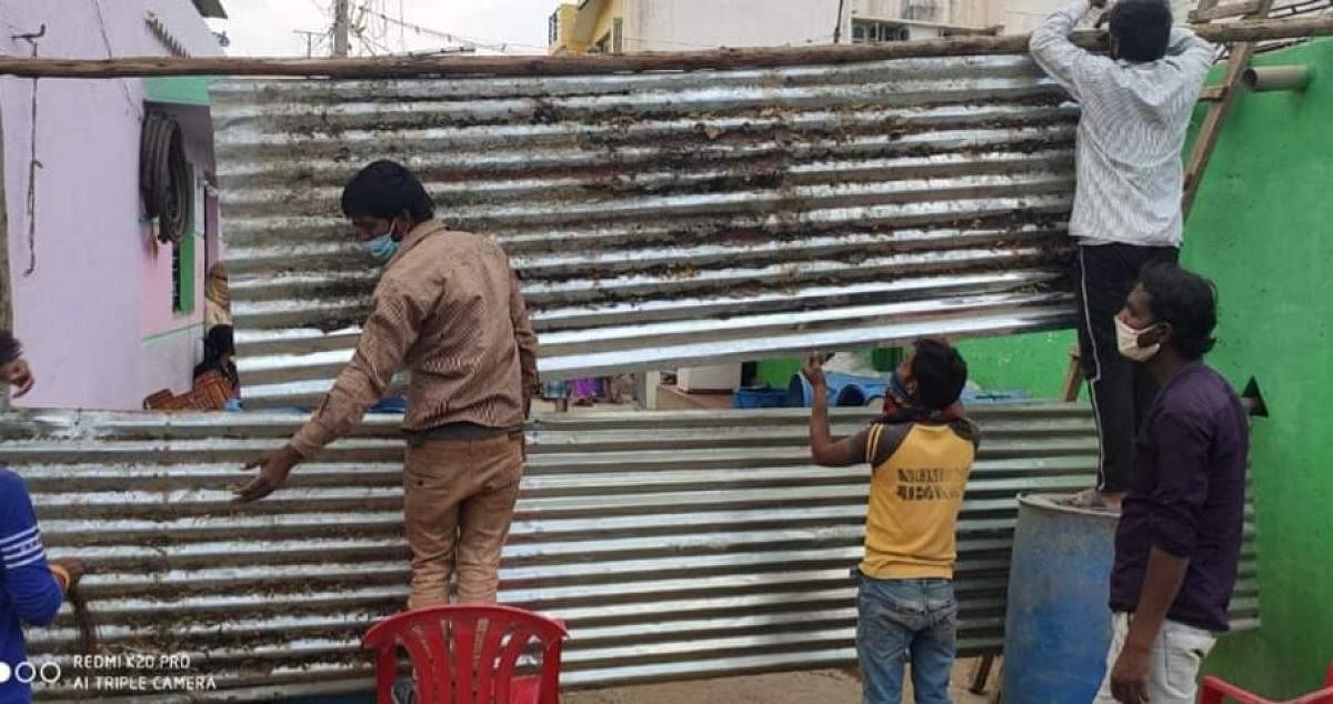 Health workers seal down Begum Mohalla in Sira city on Saturday. DH Photo.