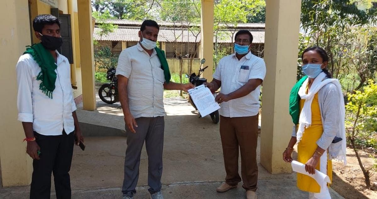 Rajya Raitha Sangha and Hasiru Sene members submit a memorandum deputy director of Department of Animal Husbandry and Veterinary Services Dr N Jagadish Kumar in Kolar on Sunday.