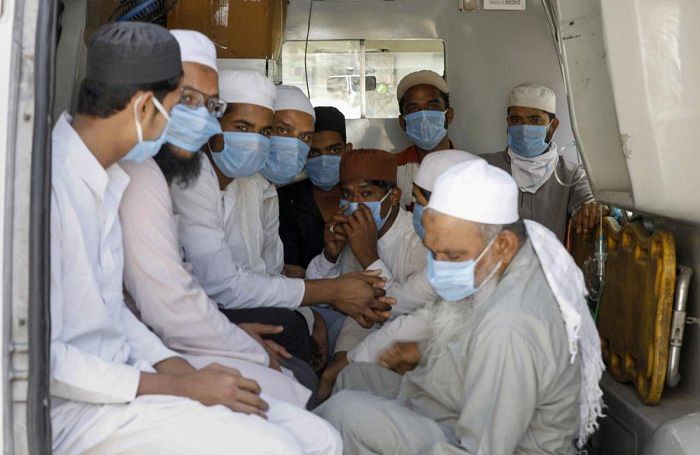Members of Muslim community who had visited several Muslim missionary gatherings including ‘Jamat’ at Nizamuddin Mosque in New Delhi, wear masks as they are being taken to a quarantine facility during a nationwide lockdown in the wake of coronavirus. (PTI Photo)