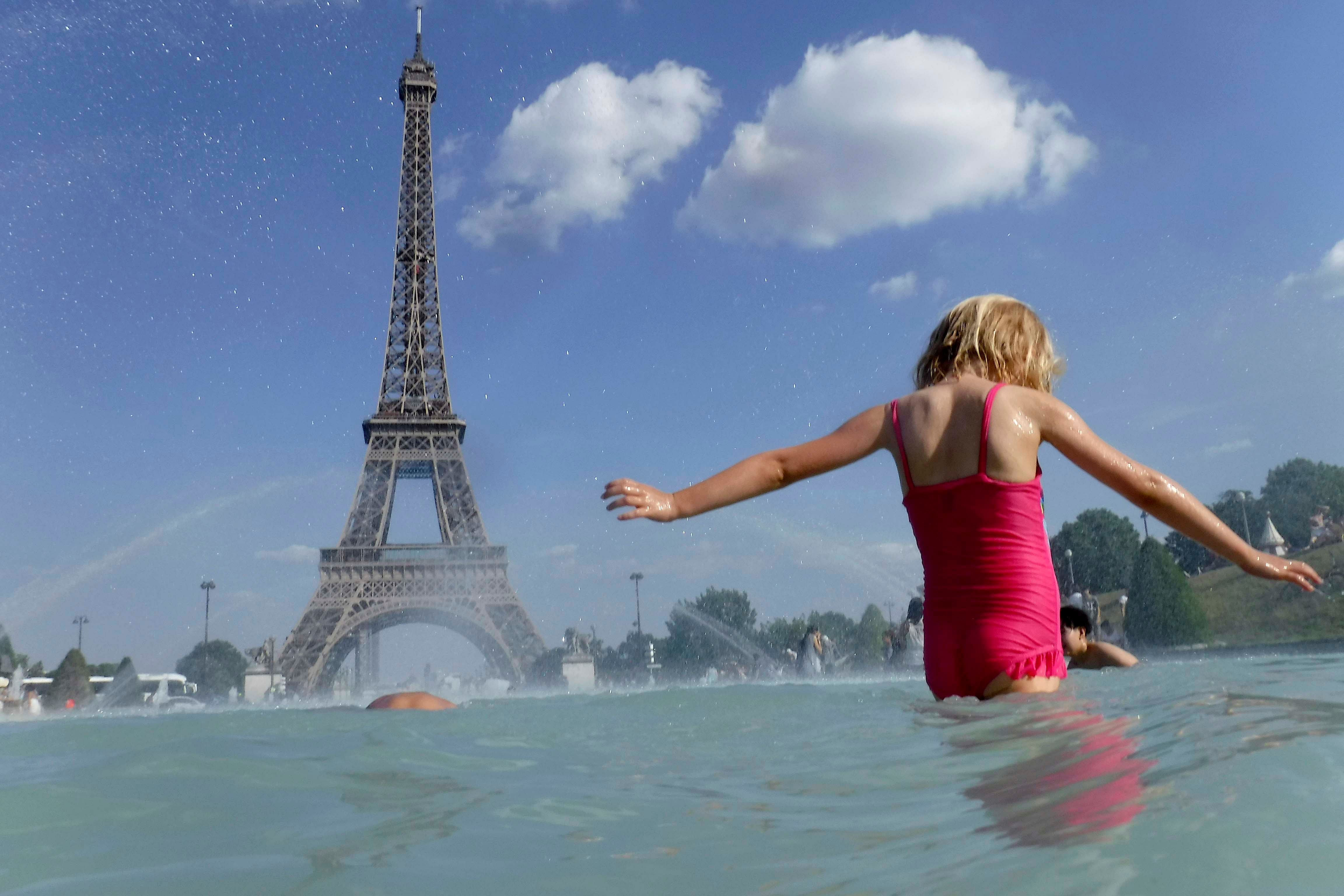 A girl cools off in the fountain of the Trocadero, in Paris, Tuesday, June 25, 2019. (Credit: AP)