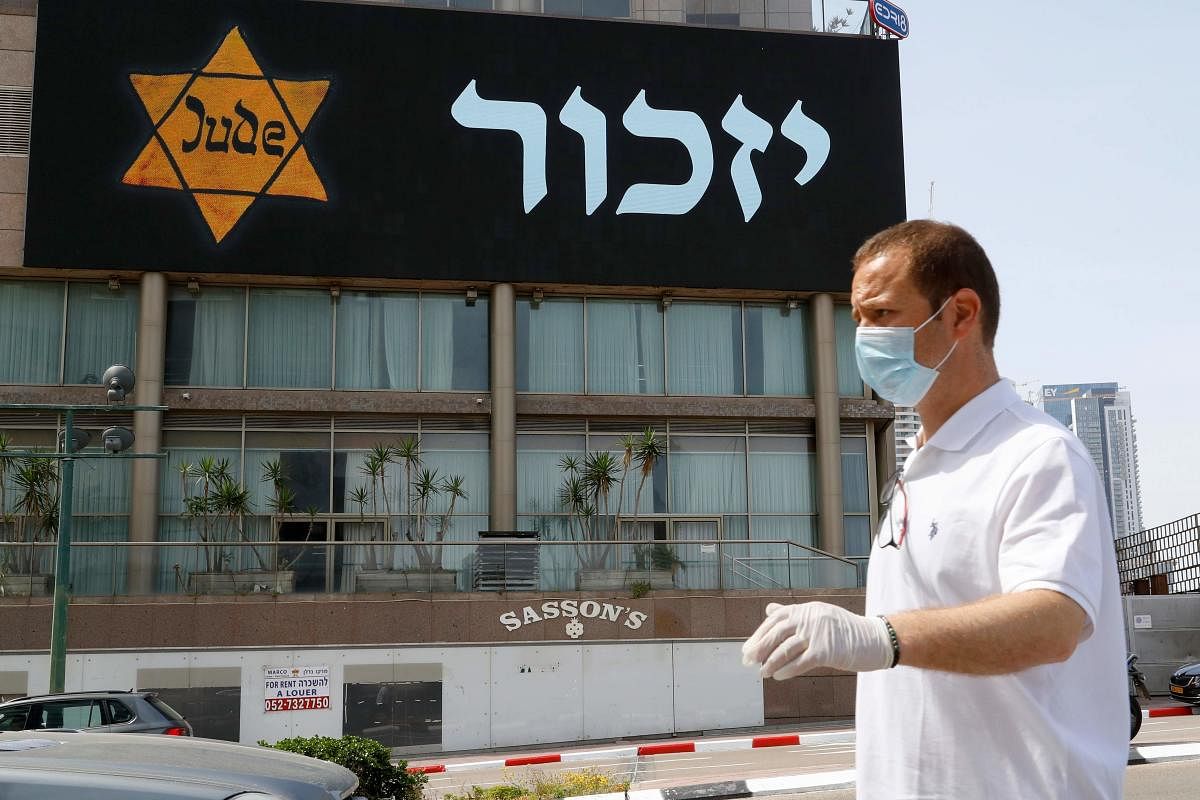 A banner depicting a yellow star of David marked with the Jew word in German and reading in Hebrew "Remember" is seen in the Israeli coastal city of Tel Aviv on April 21, 2020, as Israelis mark the annual day of remembrance for the six million Jewish victims of the Nazi genocide. Credit: AFP Photo