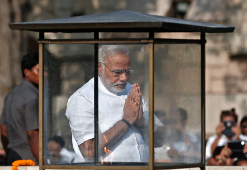 Prime Minister-designate Narendra Modi prays at the Mahatma Gandhi memorial after paying the flower tribute at Rajghat ahead of his swearing-in ceremony, in New Delhi May 26, 2014. REUTERS