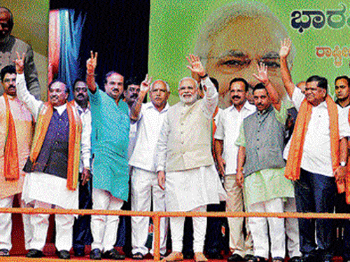 namaste bengaluru: Prime Minister Narendra Modi waves to the public at the felicitation programme organised by the State BJP on his first visit to Bangalore as prime minister  on Tuesday. BJP leaders R Ashoka, K S Eshwarappa, H N&#8200;Ananth Kumar, B S Yeddyurappa,  D V Sadananda Gowda, Pralhad Joshi and Jagadish Shettar are seen. dh Photo