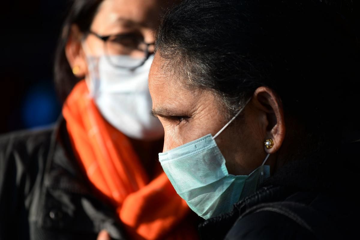 People wear facemasks amid fears of the spread of COVID-19 novel coronavirus, (AFP Photo)