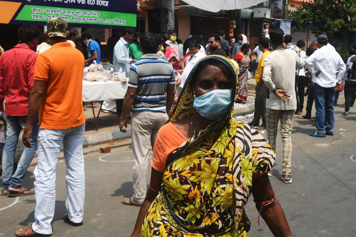 A woman wearing a facemaks leave after collecting grocery items at a distribution center organised by local clubs during a government-imposed nationwide lockdow n as a preventive measure against the COVID-19 coronavirus in Kolkata on April 5, 2020. Credit: Reuters Photo
