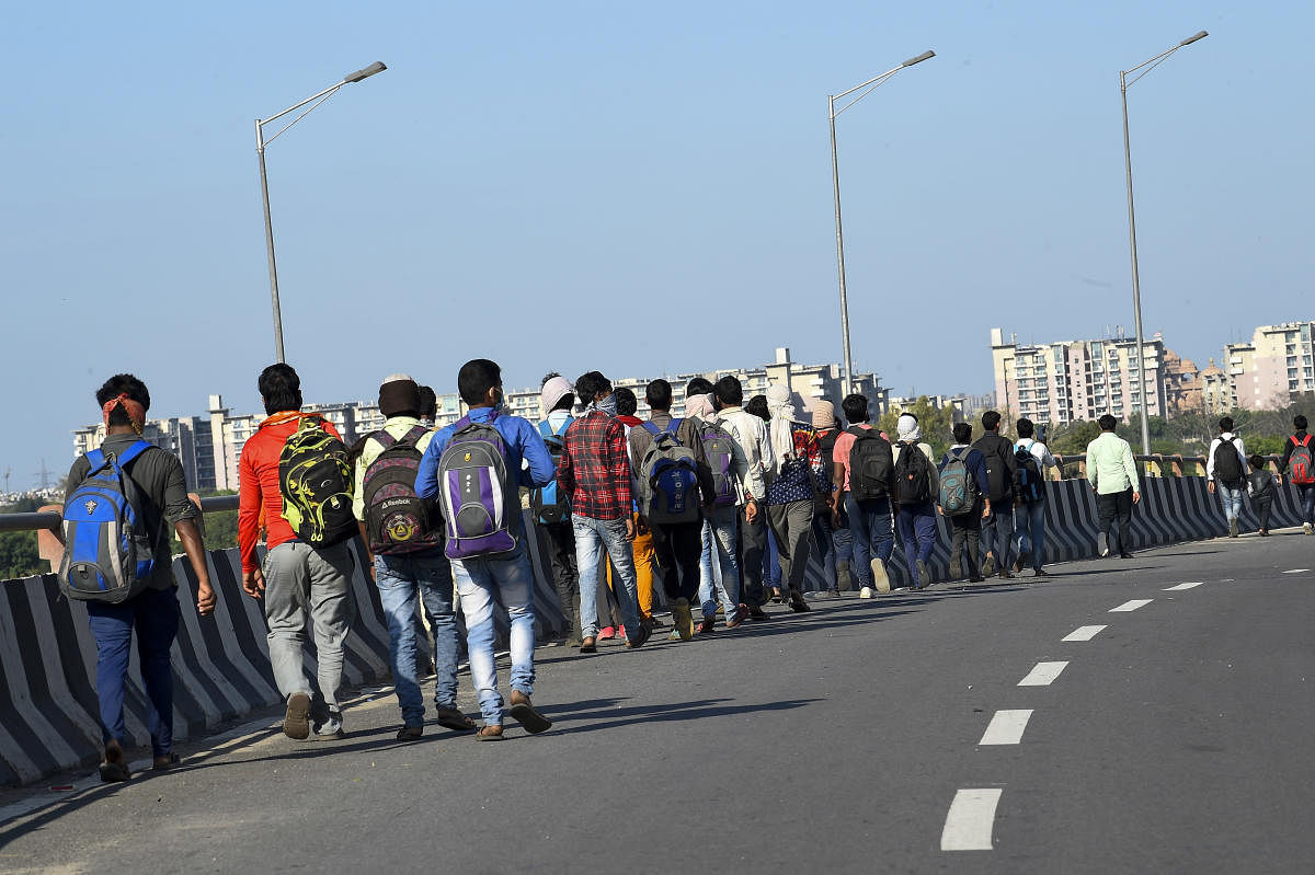 Migrant workers along with their family members walk to their villages amid the nationwide complete lockdown, in wake of coronavirus pandemic,at NH24 in New Delhi, Friday, March 27, 2020. Credit: PTI Photo