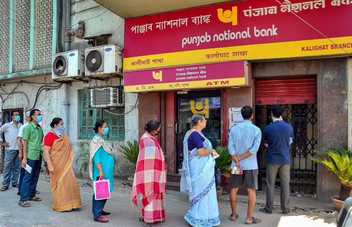 Customers, maintaining social distancing, stand outside a bank for their financial transactions during the nationwide lockdown in the wake of deadly coronavirus, in Kolkata, Monday, March 30, 2020. (PTI Photo) 