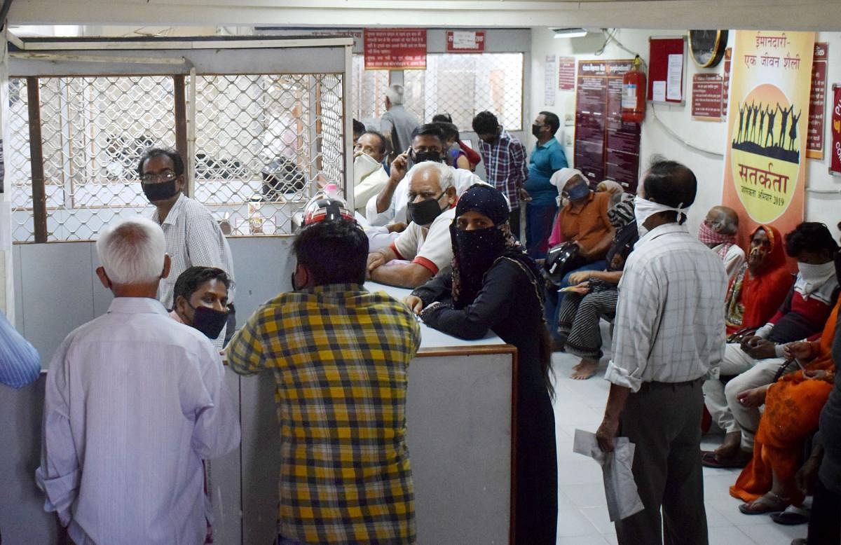 People stand in a queue to withdraw cash inside a bank during a nationwide lockdown in the wake of coronavirus pandemic, in Prayagraj, Friday, April 3, 2020. (PTI Photo)