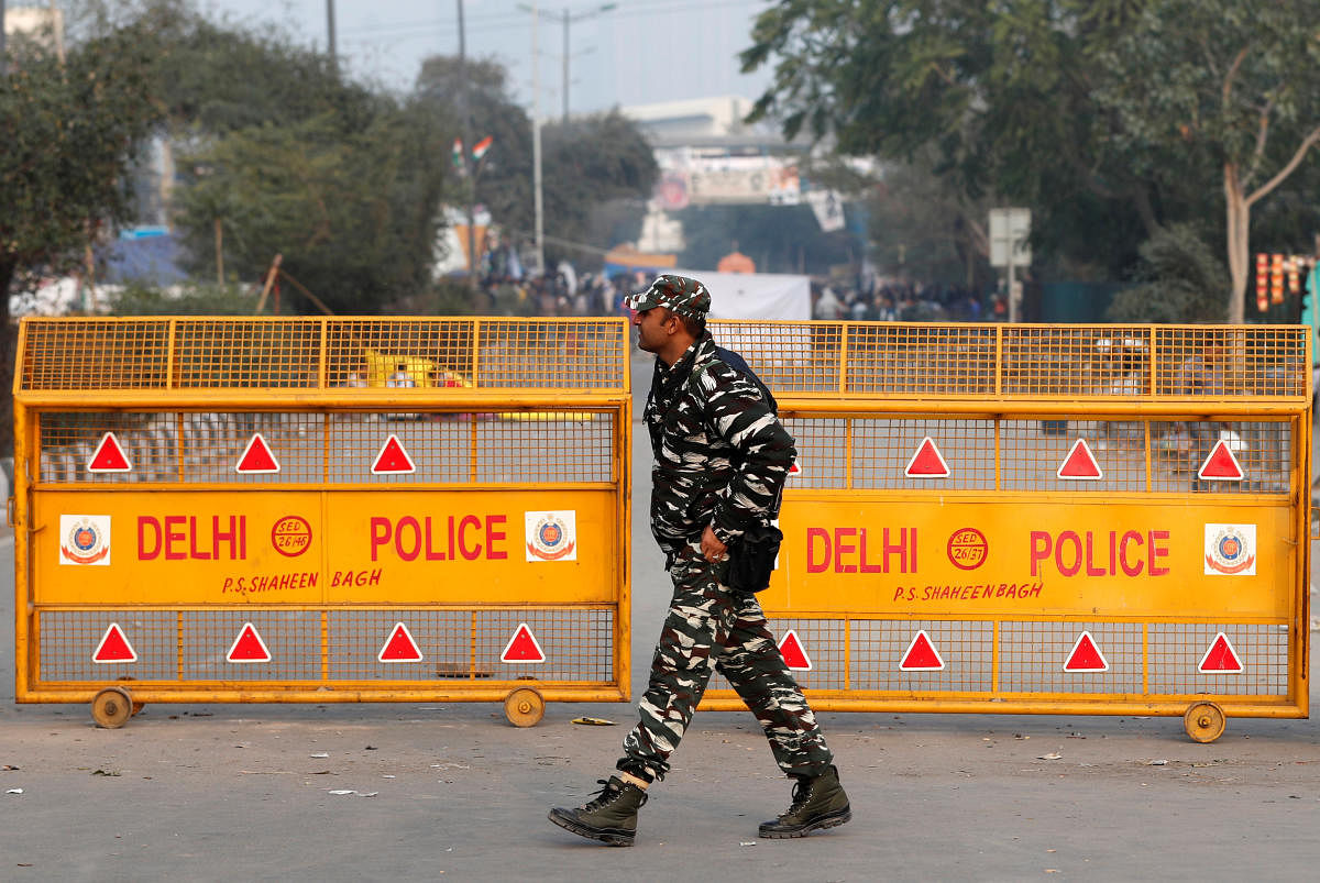  A security personnel stands beside a notice set by Delhi police at Shaheen Bagh in New Delhi. (PTI Photo)