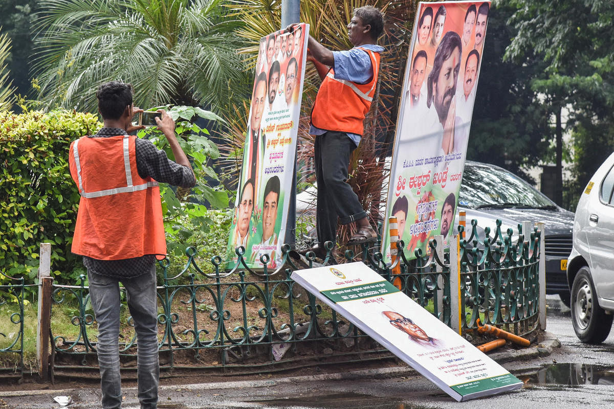 BBMP workers removing flexes around Vidhana Soudha in Bengaluru on Monday. DH Photo/S K Dinesh