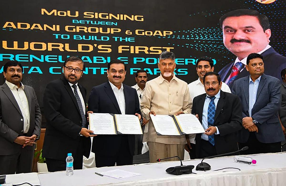Andhra Pradesh Chief Minister N Chandrababu Naidu poses for photos after signing an MoU with Adani Group, in Vijaywada. PTI Photo 