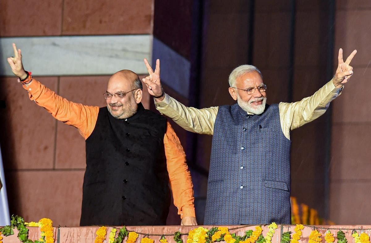Prime Minister Narendra Modi flashes the victory sign along with the party President Amit Shah to celebrate their victory in New Delhi on Thursday. PTI photo