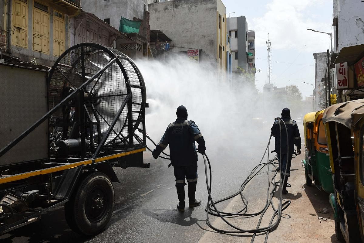Firefighters from Ahmedabad Fire and Emergency Services spray disinfectant along a street during Gujarat's government-imposed lockdown as a preventive measure against the COVID-19 (AFP Photo)