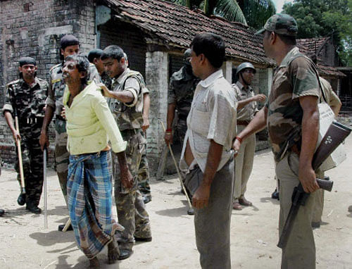 Paramilitary jawans arrest miscreants after bombing and violence during the fourth phase of the panchayat elections at Kajisha village in Beldanga, Murshidabad, West Bengal on Monday. PTI Photo