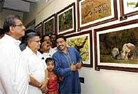 Dharmashtala Dharmadhikari Veerandra Heggade and Home Minister V S Acharya appreciating the photographs. DH Photo