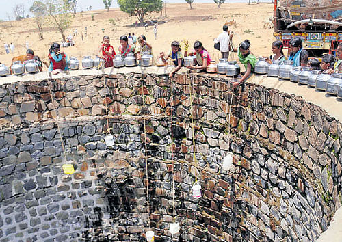 Villagers gather to fetch water after spotting a water tanker filling a well in Shahpur, Maharashtra, on Monday. PTI