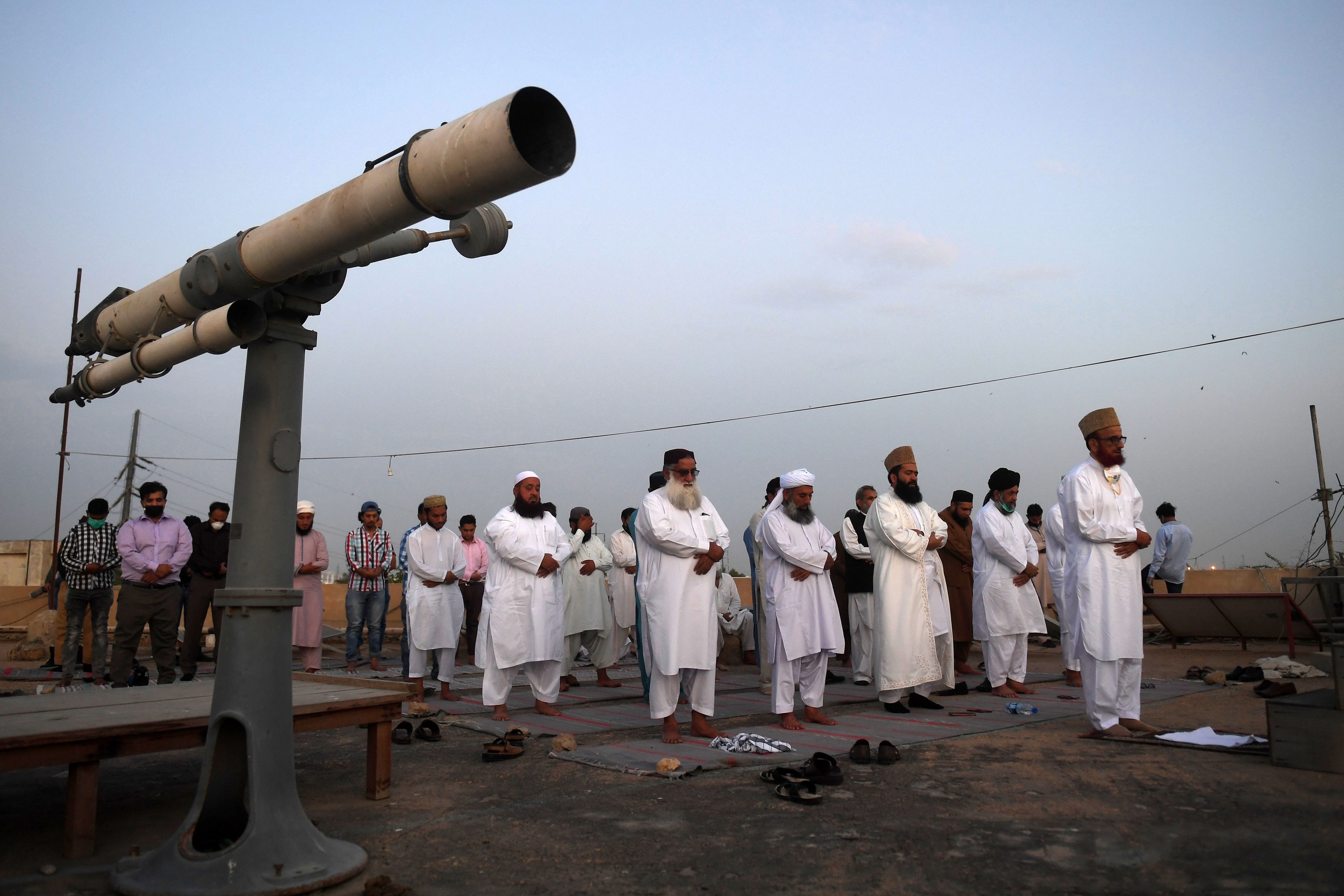 Chairman of the Pakistan Ramadan moon-sighting committee Mufti Muneeb-ur-Rehman (R) leads Magrib evening prayers before watching the Ramadan moon in Karachi. (AFP Photo)