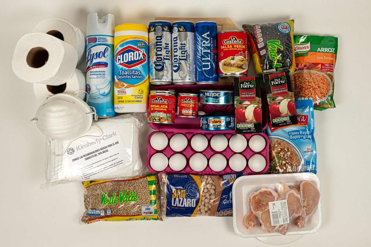 This photograph shows rolls of toilet paper, various types of face masks, a can of disinfectant spray, a container of disinfecting wipes, cans of beer, different types of canned chili, beans and tuna, a carton of eggs and a tray of chicken, items that are in high demand in Mexico as a result of the COVID-19. AFP/Representation