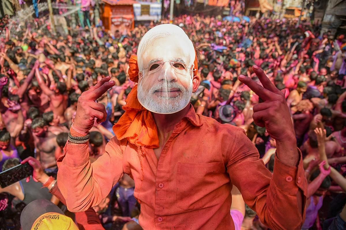 BJP supporter wears a mask of Prime Minister Narendra Modi during Holi festival celebration, in Allahabad, on Friday. PTI