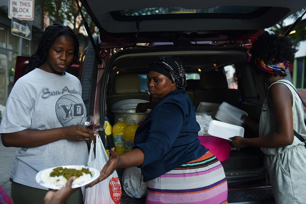 Patricia and Marceline Kamanzi help their mother, Apoline Kulimushi, an immigrant from the Democratic Republic of Congo, deliver food to asylum seekers at the Migrant Resource Center in San Antonio, Texas, U.S. (Reuters Photo)