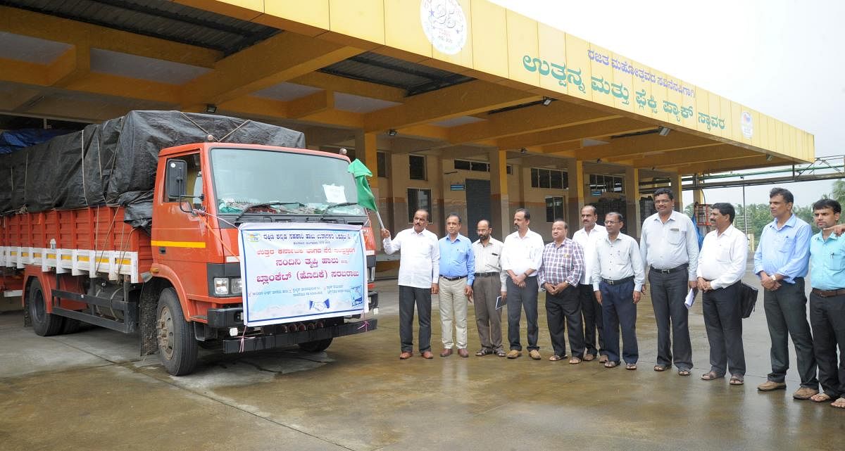DKMUL President Raviraj Hegde flags off a vehicle carrying milk and bedsheets to the flood victims.
