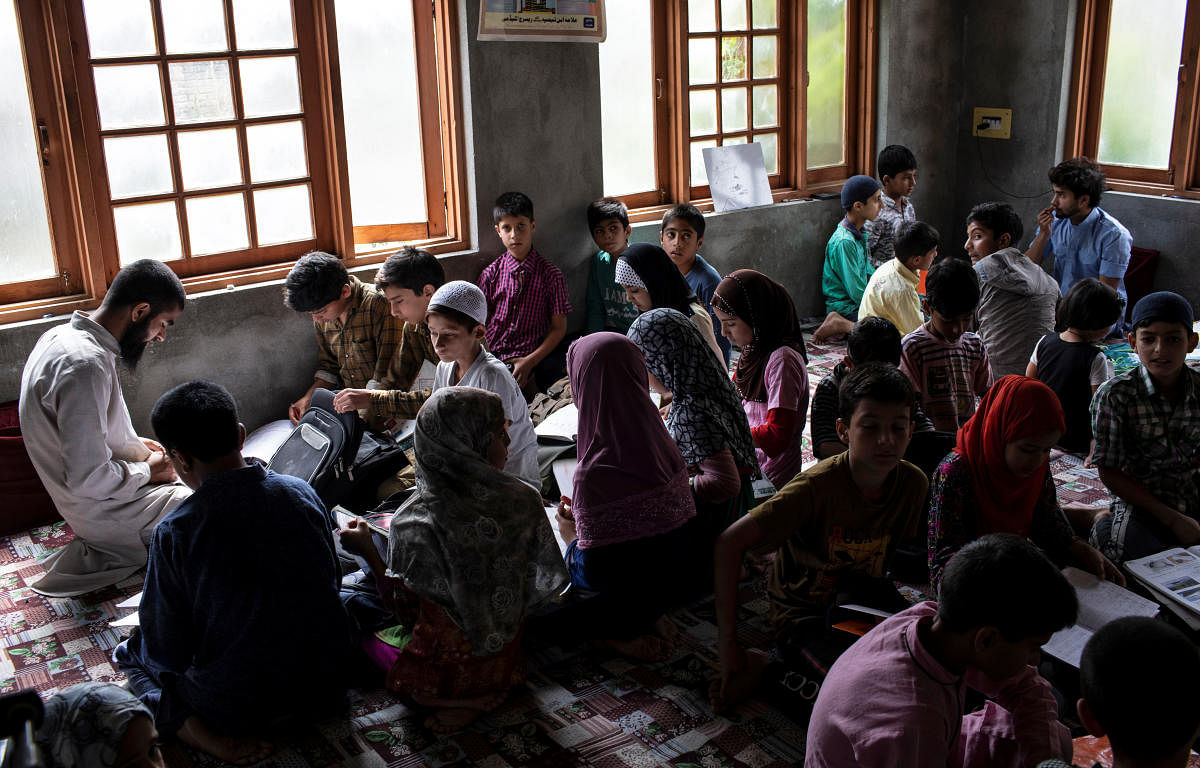 Kashmiri college students teach children inside a house in Anchar neighbourhood. (Photo by Reuters)