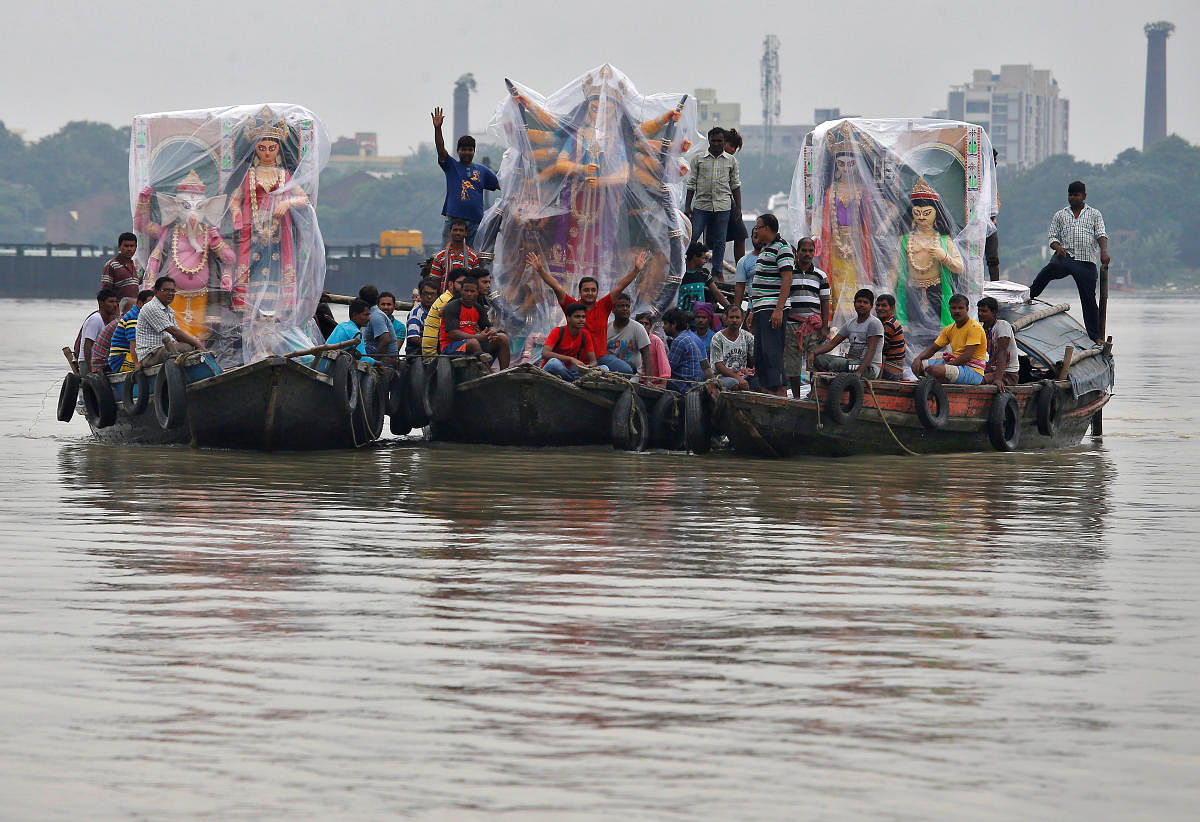 Idols of the Hindu goddess Durga covered in plastic sheets are transported on boats in the waters of river Ganga to pandals, in Kolkata. (Photo by Reuters)