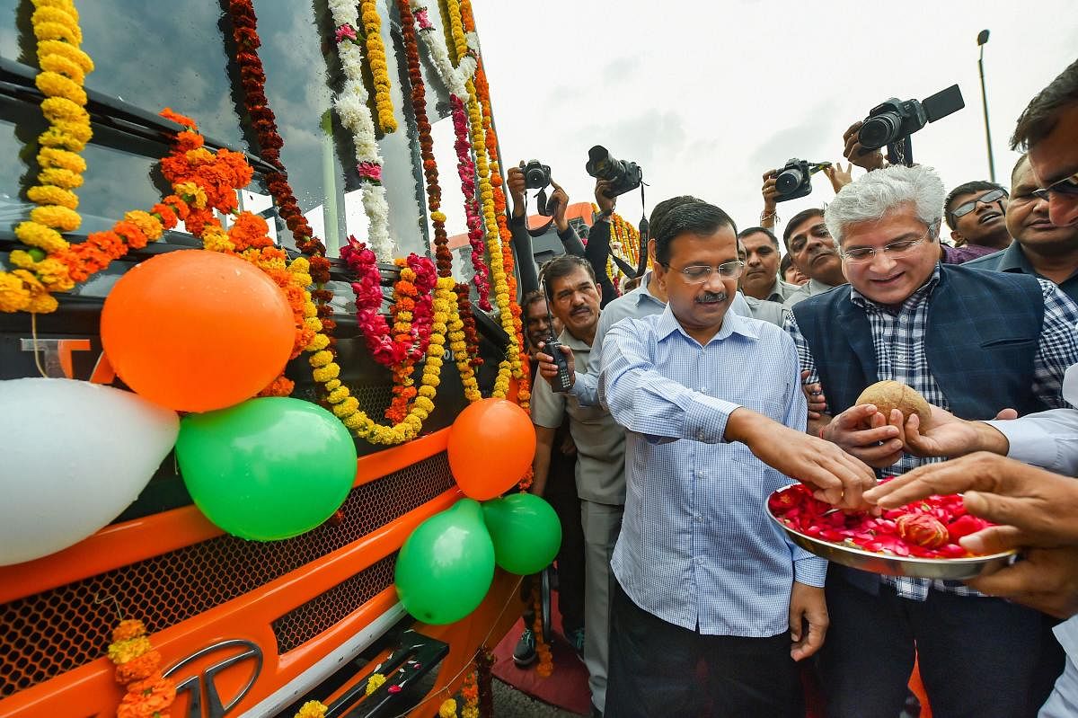 Delhi Chief Minister Arvind Kejriwal and state Transport Minister Kailash Gahlot during flag-off ceremony of 100 new ultra modern CNG standard floor buses, at Rajghat Bus Depot in New Delhi on Thursday. (PTI Photo)