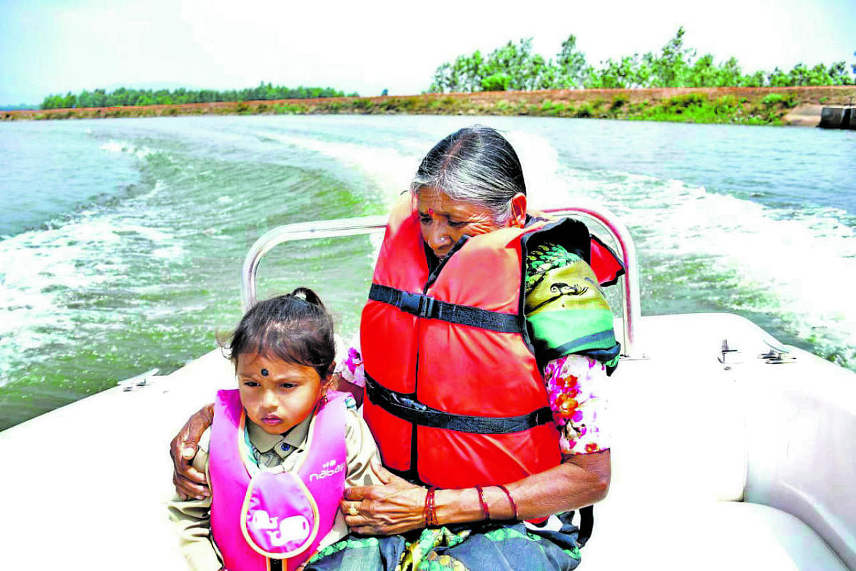 Parvathamma, along with her grandchild, takes a boat ride, at Nallooru Kere in Chikkamagaluru.