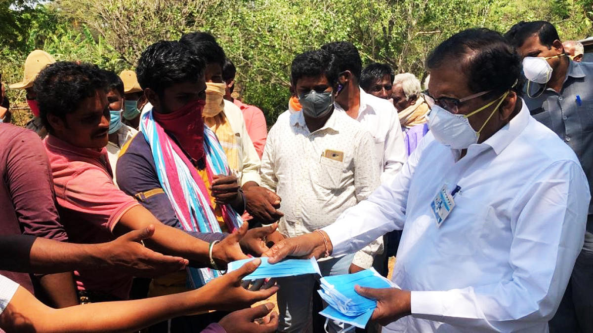 Koratagere MLA G Parameshwara distributes masks to people in his constituency in Tumakuru district on Wednesday. DH Photo.