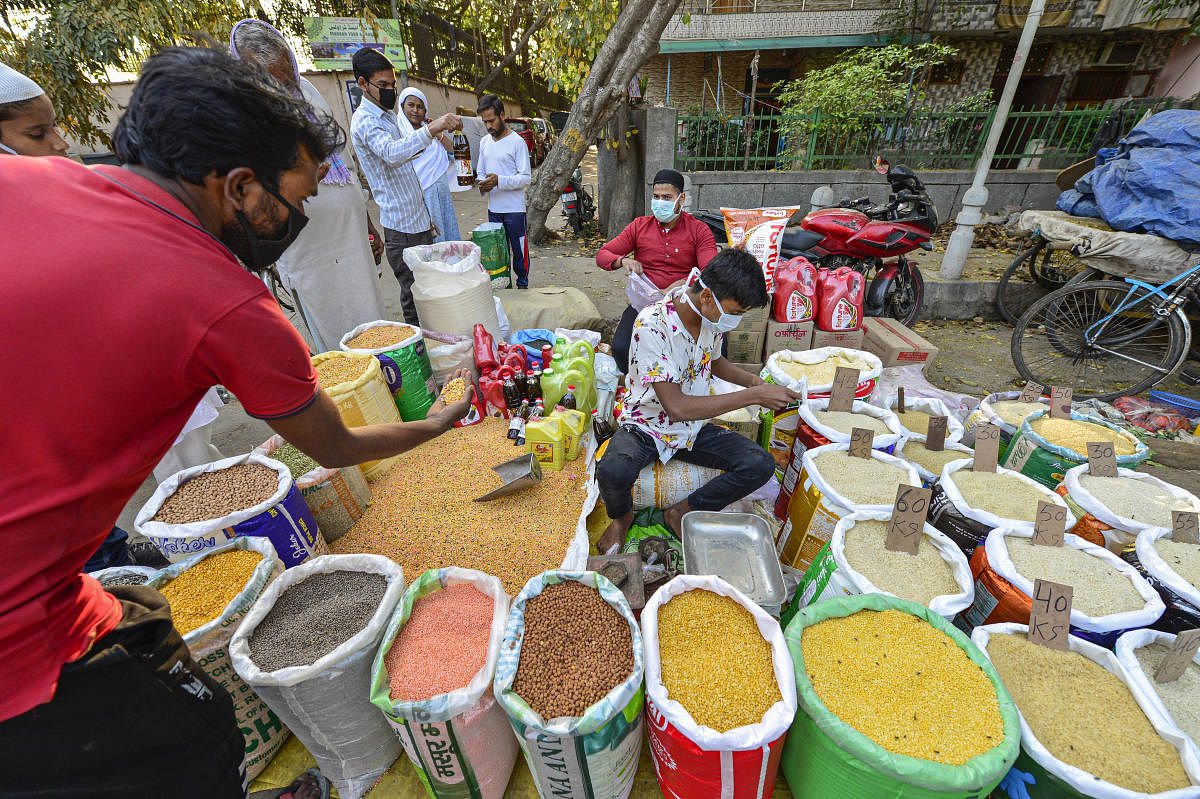 People purchase pulses from a roadside vendor during the nationwide lockdown, in wake of coronavirus outbreak, in New Delhi, Friday, March 27, 2020. (PTI Photo)