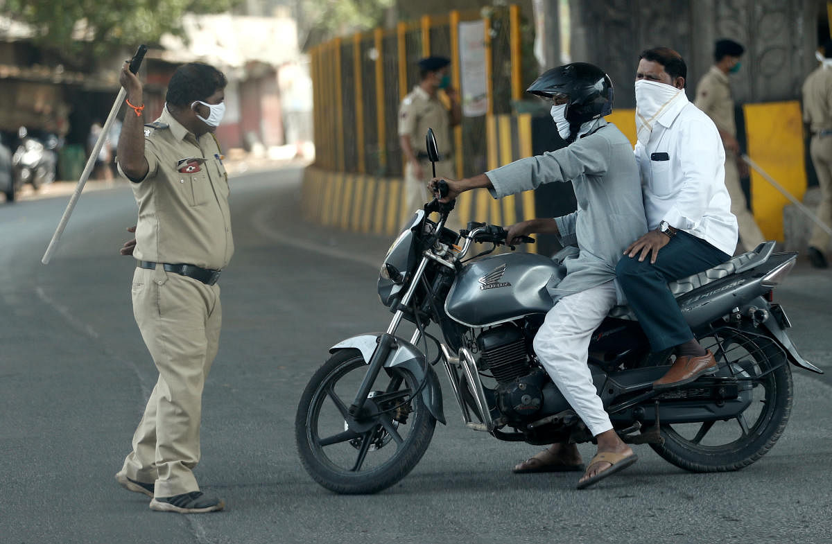 A policeman wields his baton at a man riding a motorbike as a punishment for breaking the lockdown rules, after India ordered a 21-day nationwide lockdown to limit the spreading of coronavirus disease (COVID-19) in Mumbai, India March 25, 2020. Credit: Reuters Photo