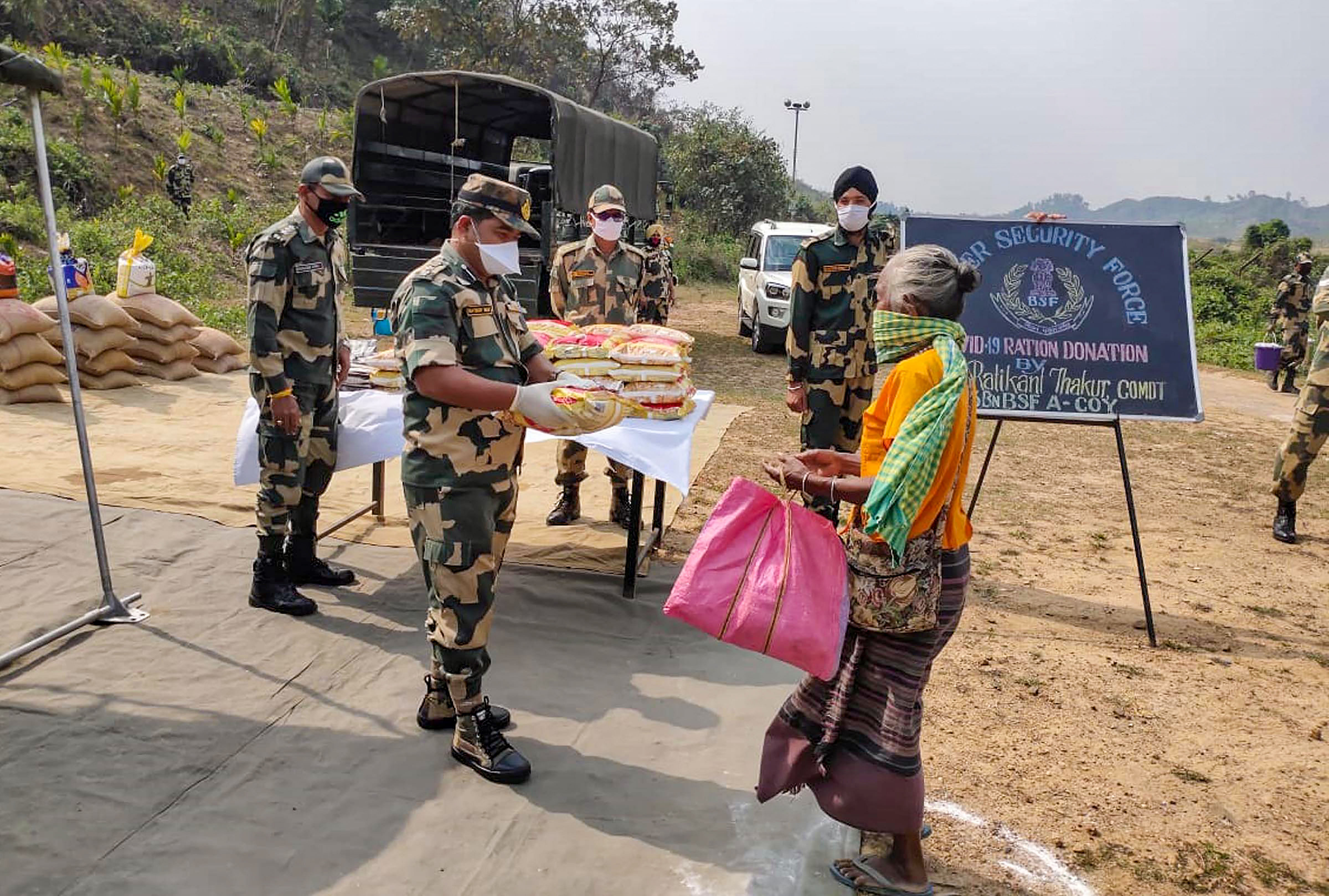 Officials of 43 Battalion of Border Security Force (BSF) distribute ration amongst the needy people during the nationwide lockdown, imposed in the wake of coronavirus pandemic. (Credit: PTI Photo)