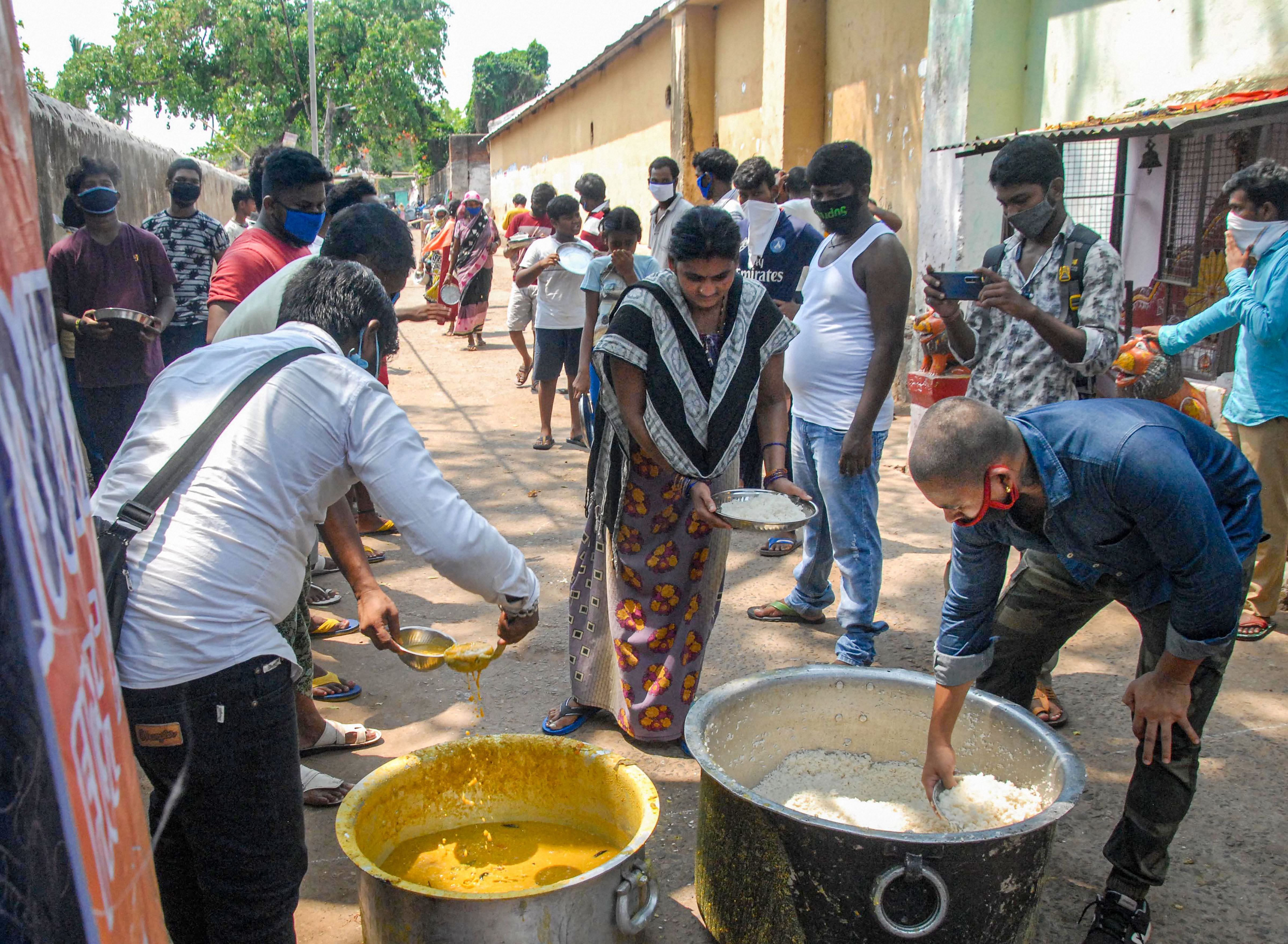 Volunteers distribute free meals among needy people during the nationwide lockdown, in wake of the coronavirus pandemic, in Bhubaneswar. (Credit: PTI Photo)
