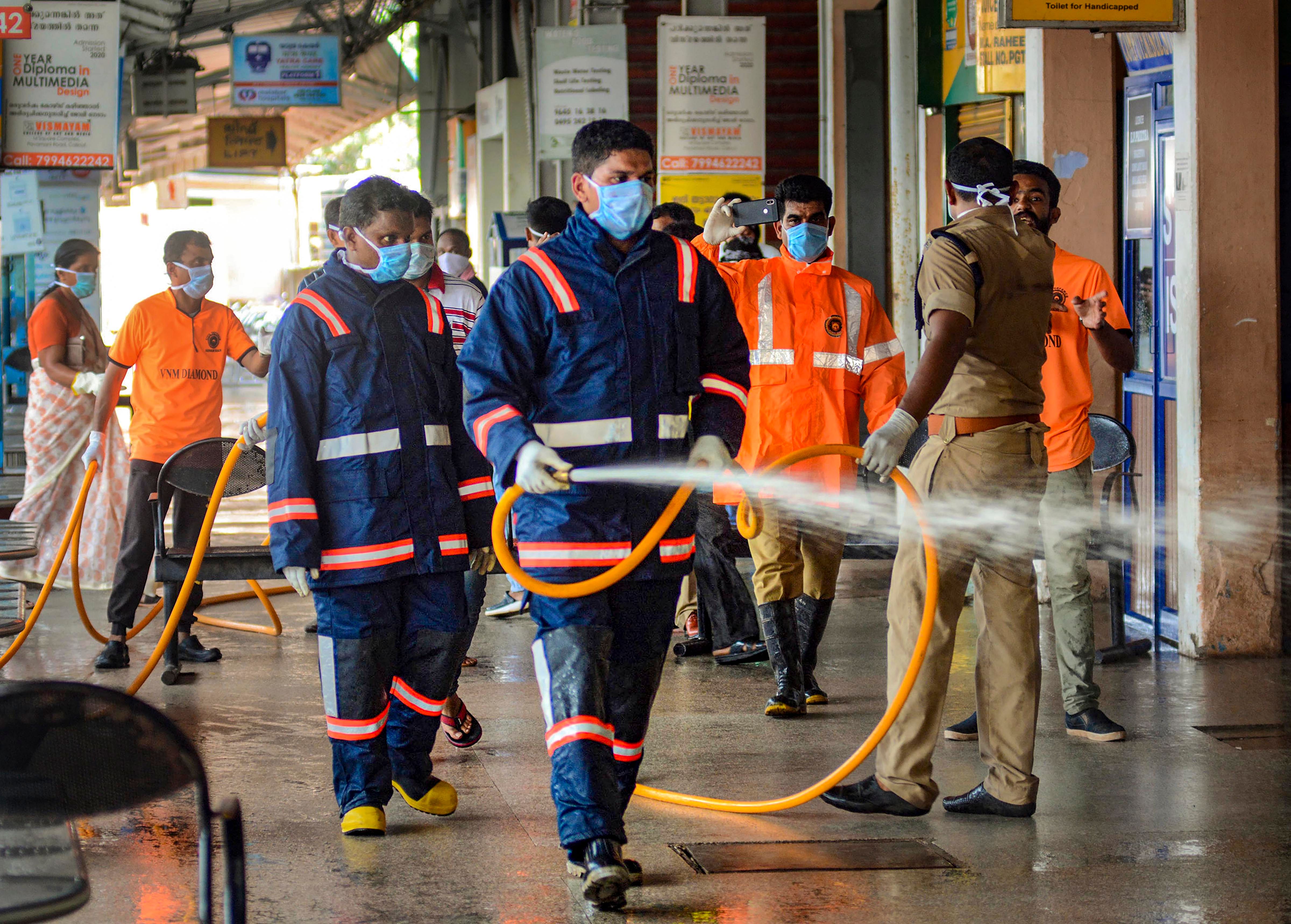  Workers spray disinfectant in the premises of KSRTC bus stand to contain the spread of coronavirus. (PTI Photo)