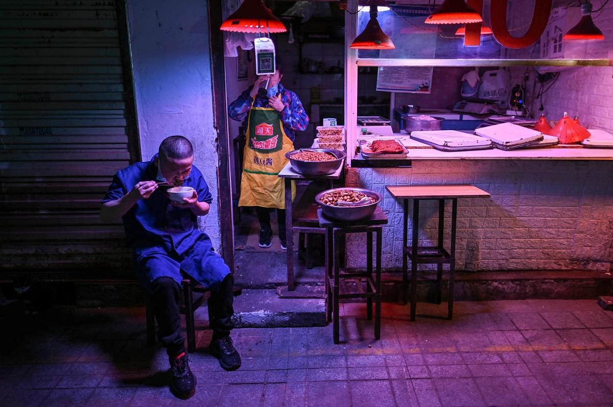 Perosn eating in Wuhan market (AFP Photo)