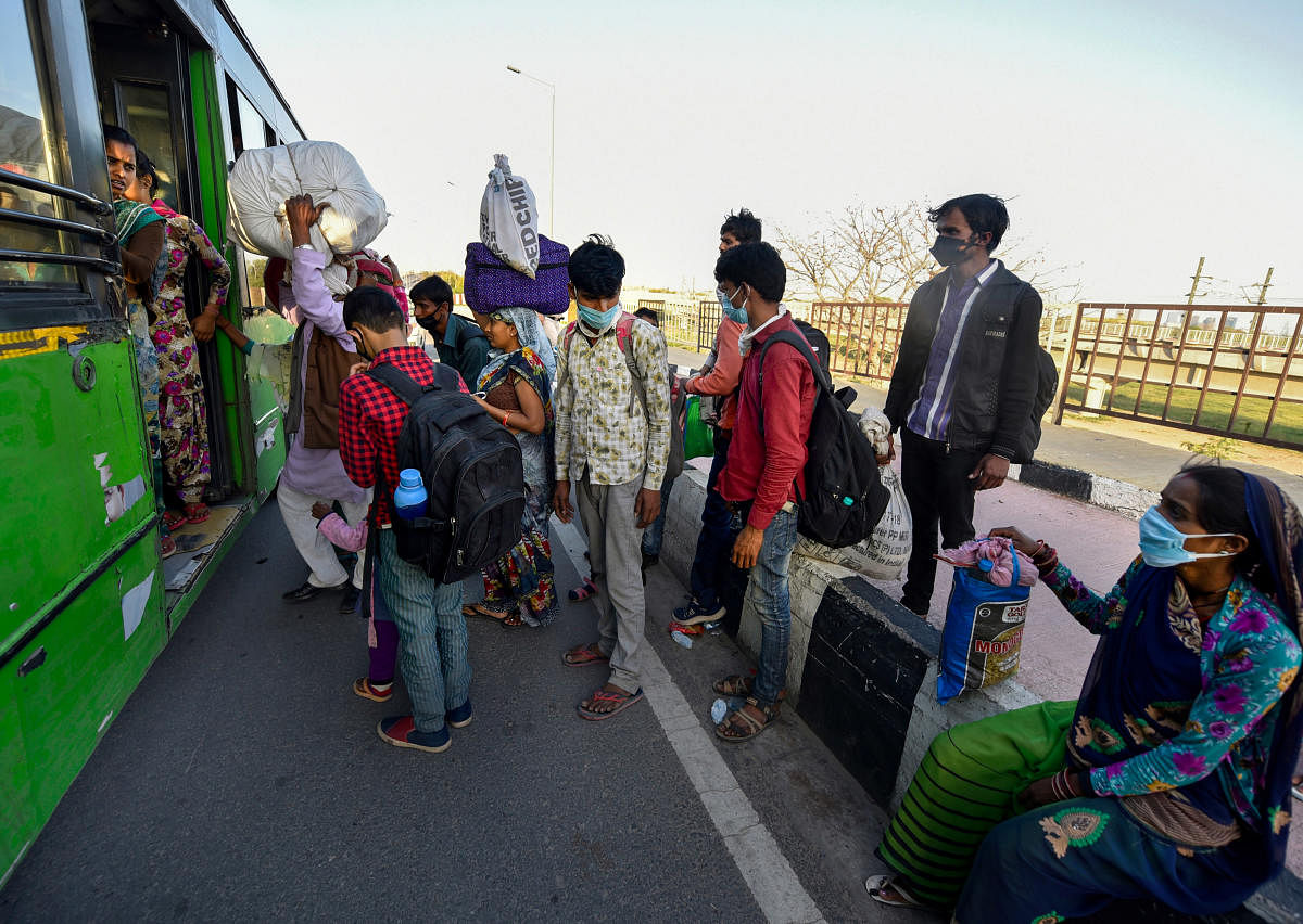 Migrant workers board a DTC bus at NH24 during the nationwide coronavirus lockdown, in East Delhi. PTI