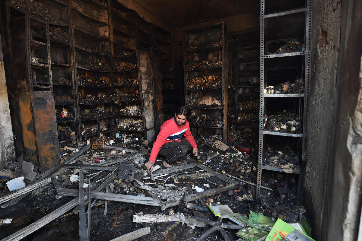  A shopkeeper sorts through the charred remains of a vandalized and burned shop, following Tuesday's violence, at Khajuri Khas extension area of northeast Delhi, Friday, Feb. 28, 2020. Credit: PTI Photo