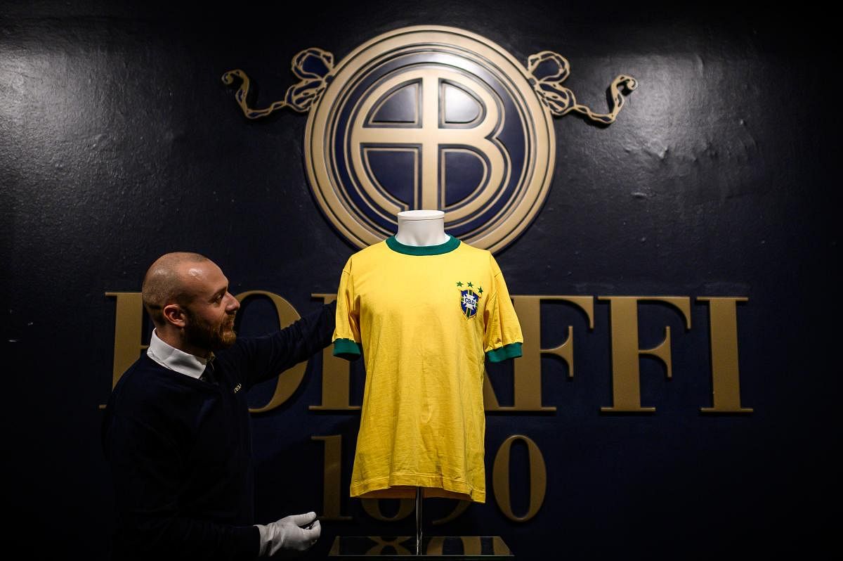 A staff member displays a jersey of Brazilian football legend Pele, during a preview of Sport Memorabilia items, at the Bolaffi auction house in Turin. Photo/AFP
