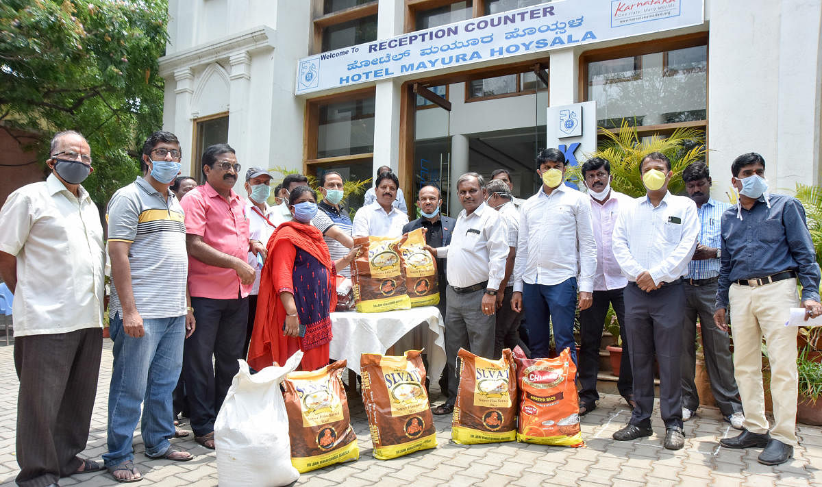Registered tourist guides being provided groceries in the wake of the nation-wide lockdown in view of the spread of coronavirus or Covid-19, in Mysuru recently. Mysuru Hotel Owners Association president C Narayana Gowda is seen. dh photo