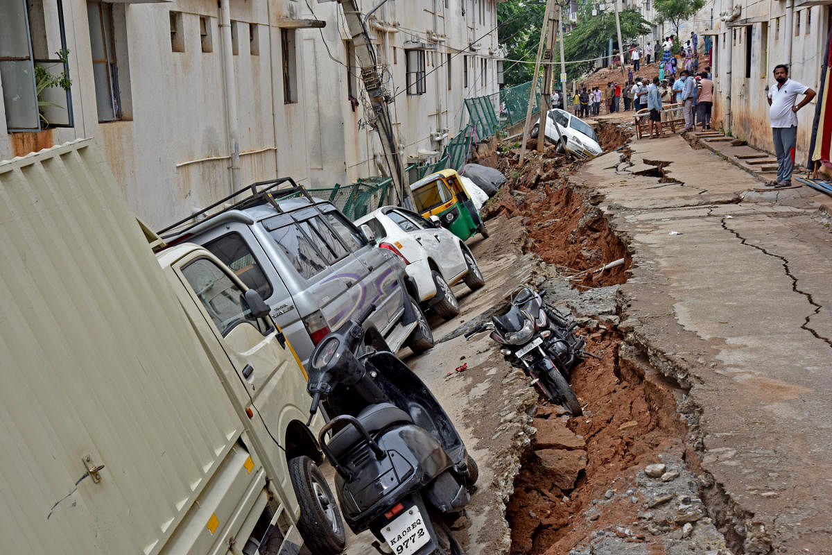 A road that caved in Lakshmidevi Nagar, Laggere, in Friday's thunderstorm. DH PHOTO/M S MANJUNATH