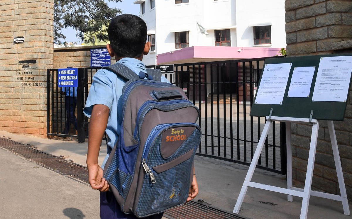 A School child return back to home, after the Government announce holiday for the 1st to 5th standard, on coronary virus infection cases in Bengaluru, at T Dasarahalli, in Bengaluru on Tuesday. (DH Photo/ B H Shivakumar)