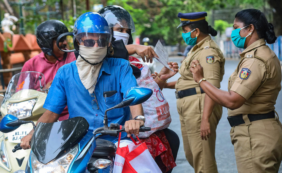 Police personnel question commuters who defied curfew during a 21-day nationwide lockdown, in the wake of coronavirus pandemic, in Kozhikode, Wednesday, March 25, 2020. (PTI Photo)